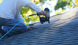 Homeowner reviewing a roofing estimate with a contractor beside a house roof inspection.