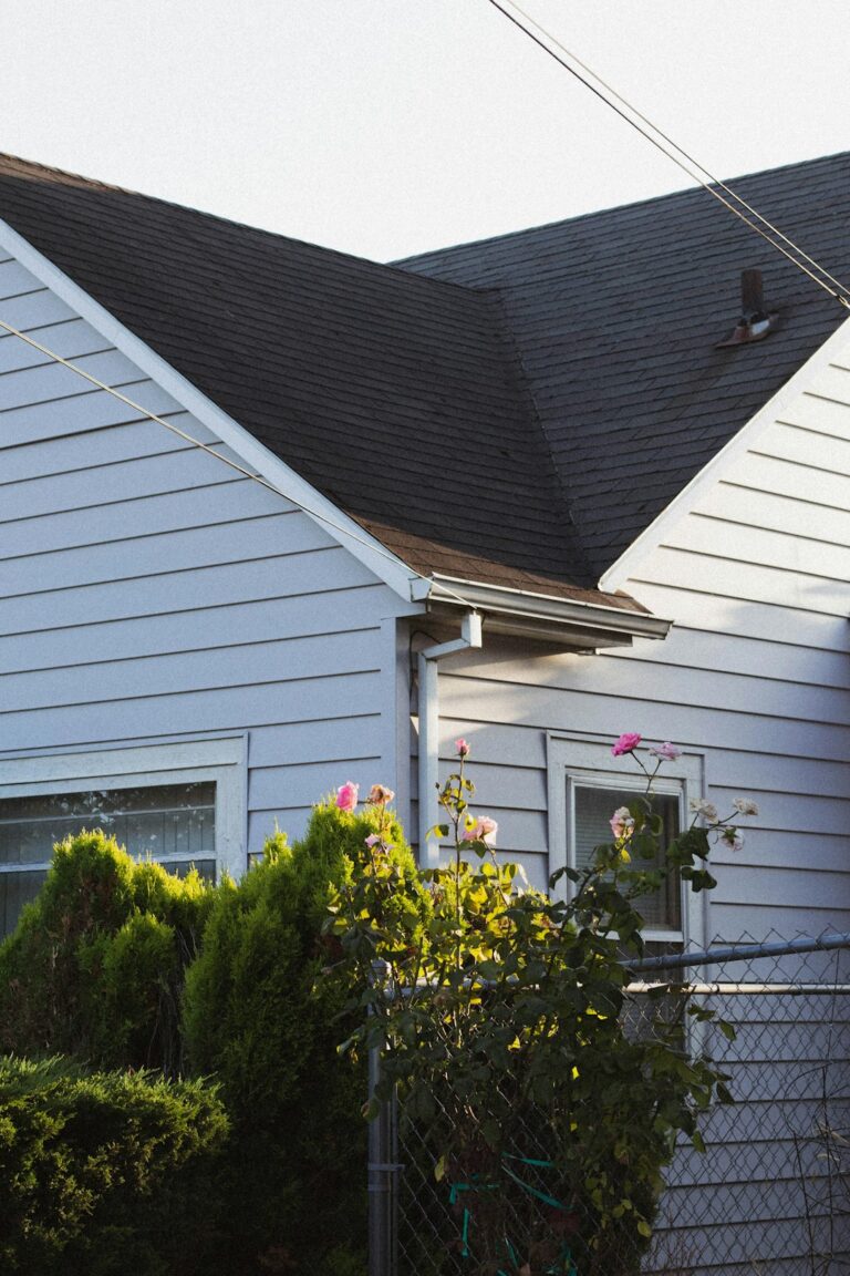 A homeowner examines bruised roof shingles and dented metal flashing after a hailstorm.